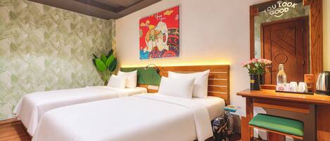 Habitación de hotel con dos camas, cabecero de madera, un cartel en la pared, un espejo y una mesita con artículos de aseo.