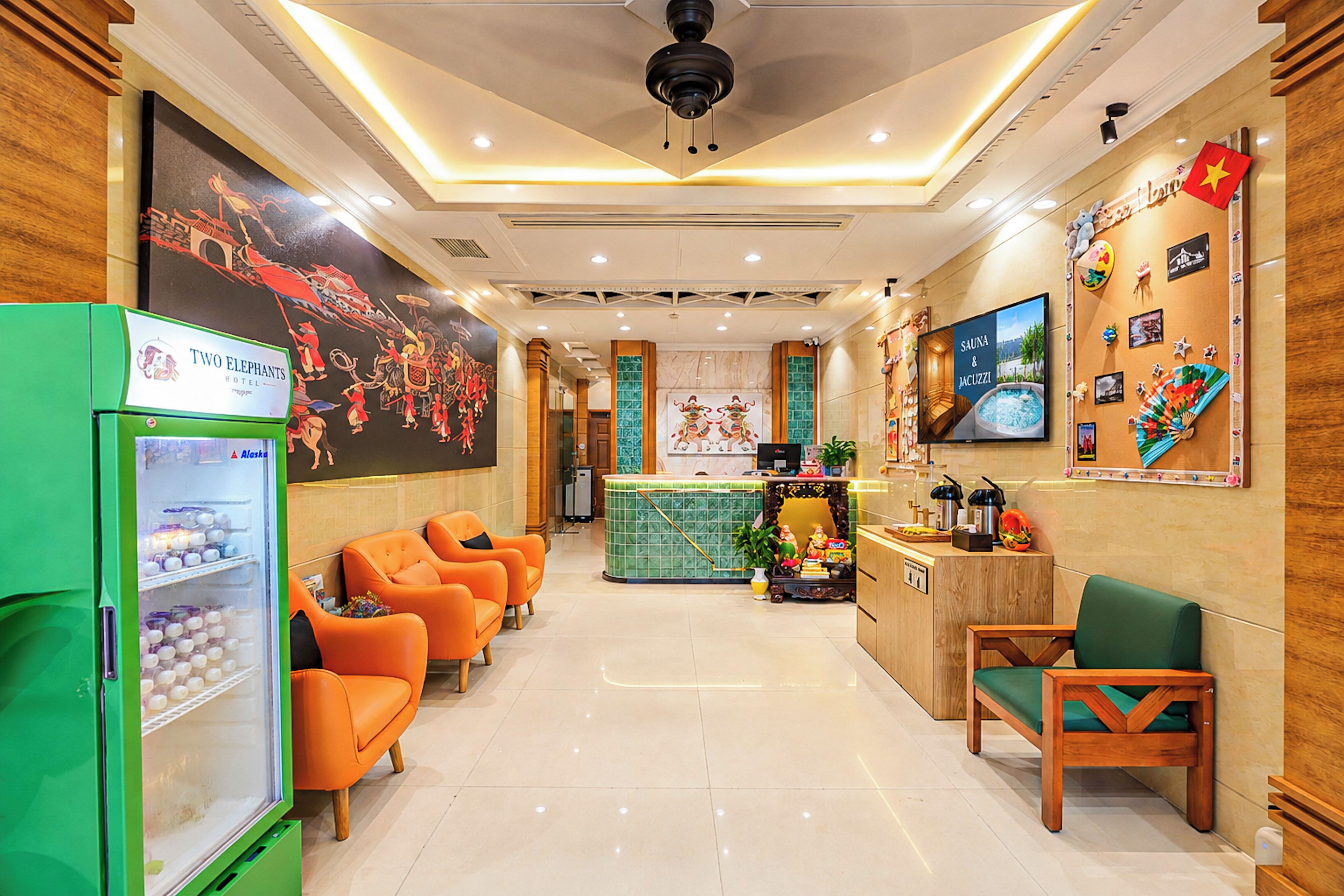 Un hall de hotel con mostrador de recepción, zona de estar y un refrigerador.