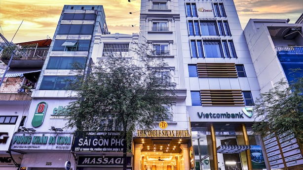 Ein Hotel mit moderner Fassade, einem gut sichtbaren Eingang und dem Schild 'Sài Gòn PHC'.