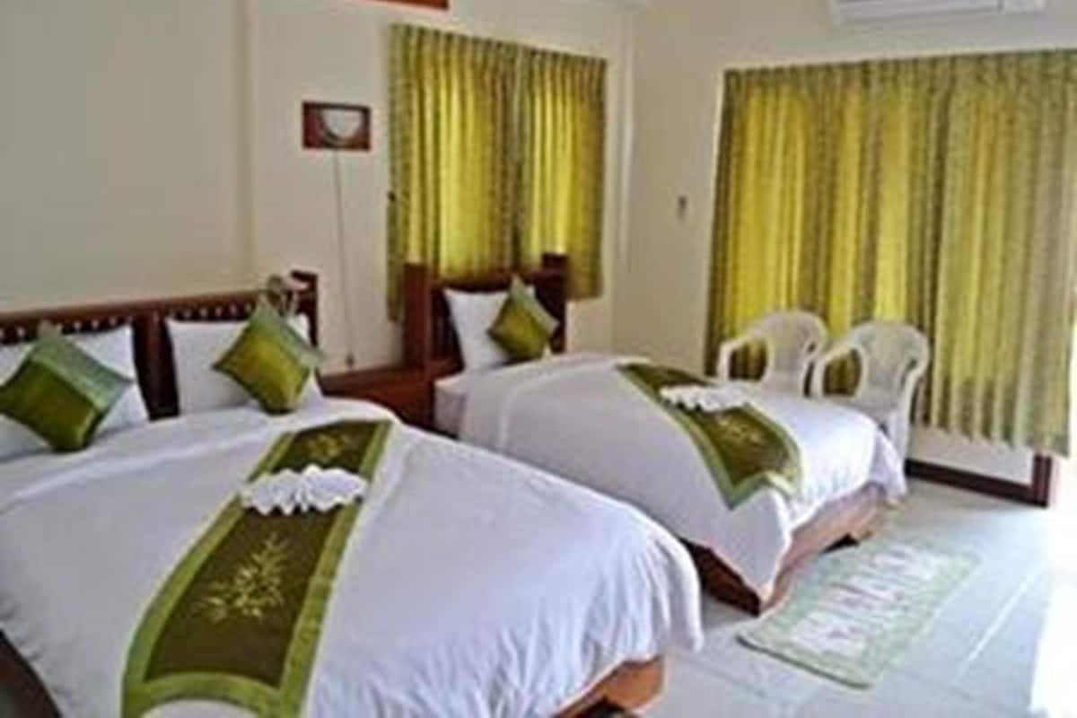 A hotel room with two beds, a desk, and a chair.