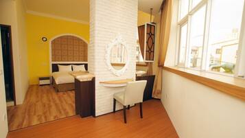 A bedroom with a bed, a desk, and a chair.