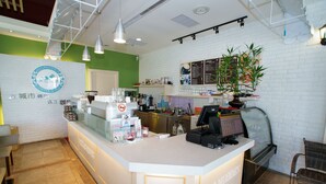 A coffee shop interior with a counter, seating area, and a menu board. - Venice B&B (Taitung)