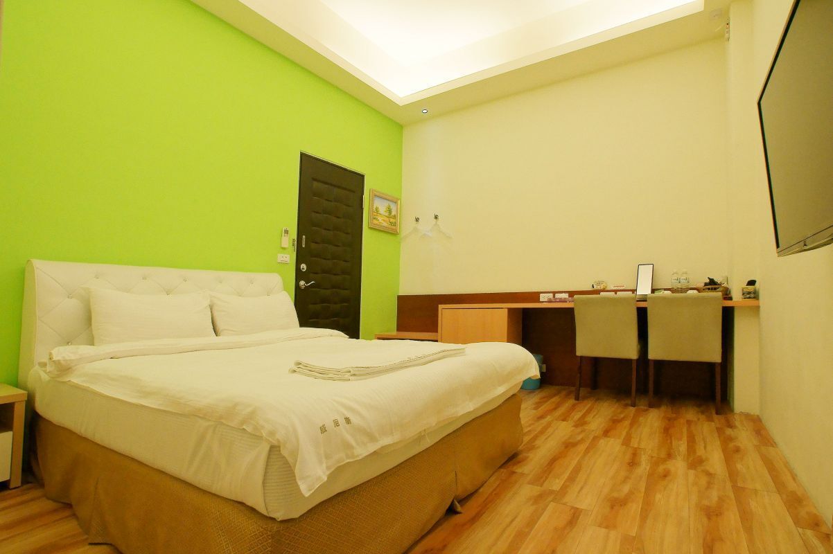 Un dormitorio con cama, escritorio y silla.