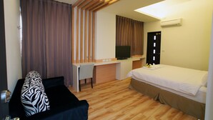 A hotel room with a bed, a desk with a computer, a chair, and a television. - Venice B&B (Taitung)