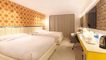 A hotel room with two beds, a desk, a chair, a TV, and a patterned wall.