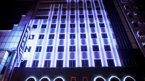 Un edificio de gran altura con una cuadrícula de ventanas iluminadas en azul.