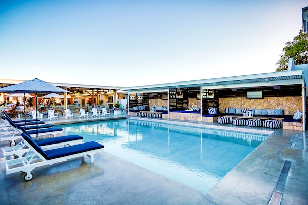 Una piscina al aire libre, camas de piscina gratis, sombrillas