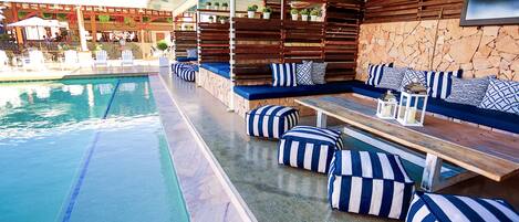 A poolside area with seating and a stone wall.