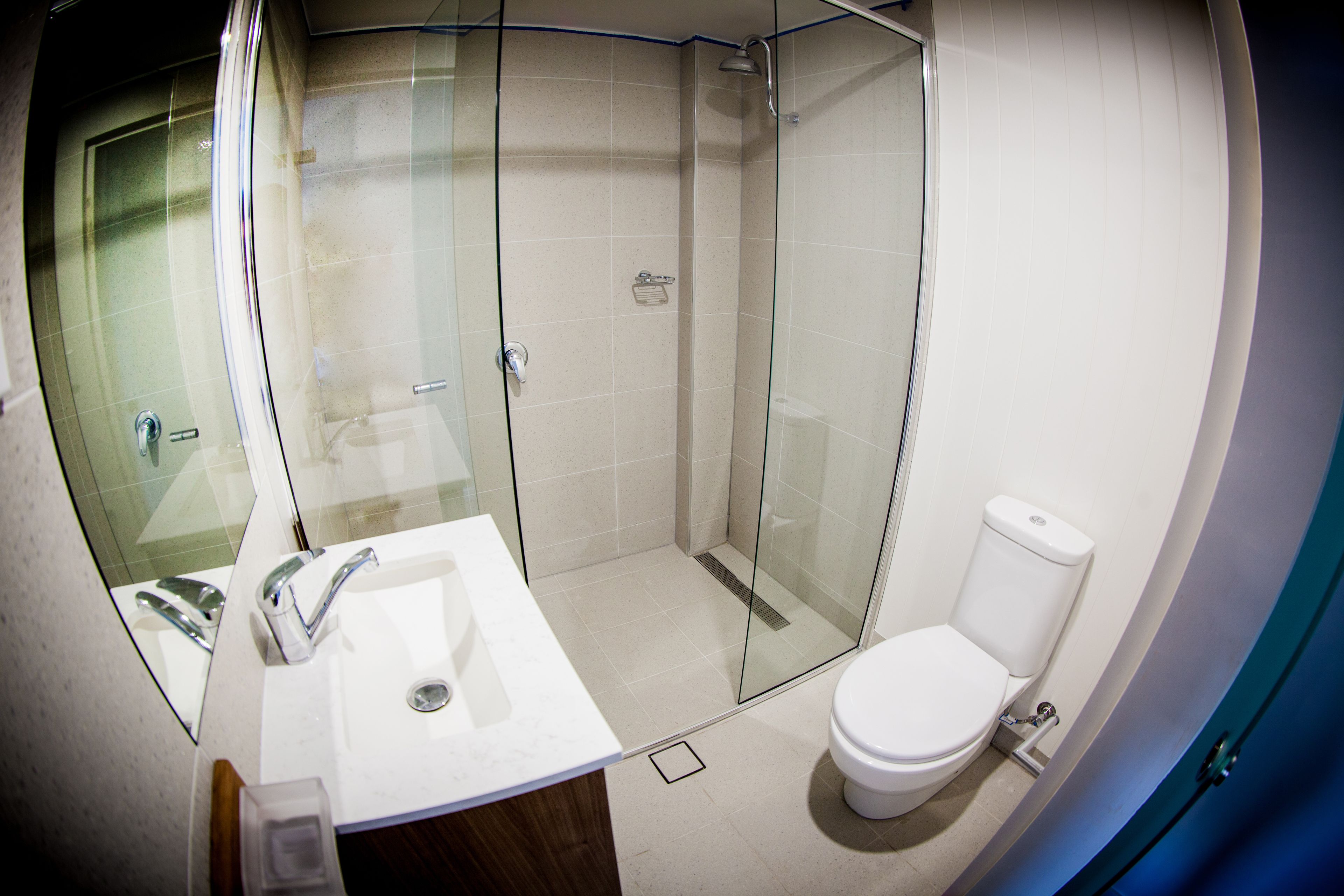 Ein modernes Badezimmer mit Duschkabine aus Glas, einem weißen Waschbecken und einer Toilette.