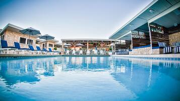 Relax by the serene pool surrounded by lounge chairs and a covered seating area.