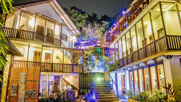 A multi-story building with a staircase leading to the upper floors, surrounded by lush greenery. - Hotel Sunray (Kandy)