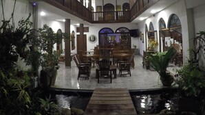 A spacious atrium with a central dining area, multiple balconies, and a water feature at the bottom. - Hotel Sunray (Kandy)