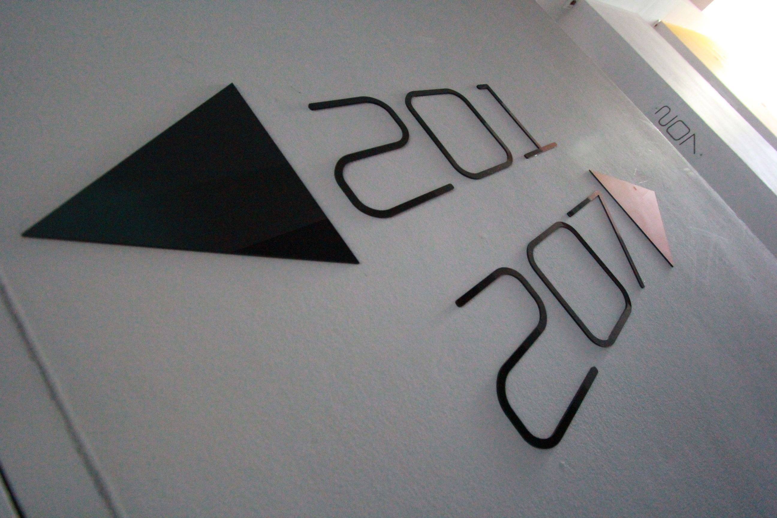 Eine Wand mit den Nummern 201 und 207 in einer modernen Schriftart.