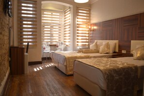A hotel room with two beds, wooden flooring, and a brick wall. - Blue Istanbul Gedikpasa (Istanbul)