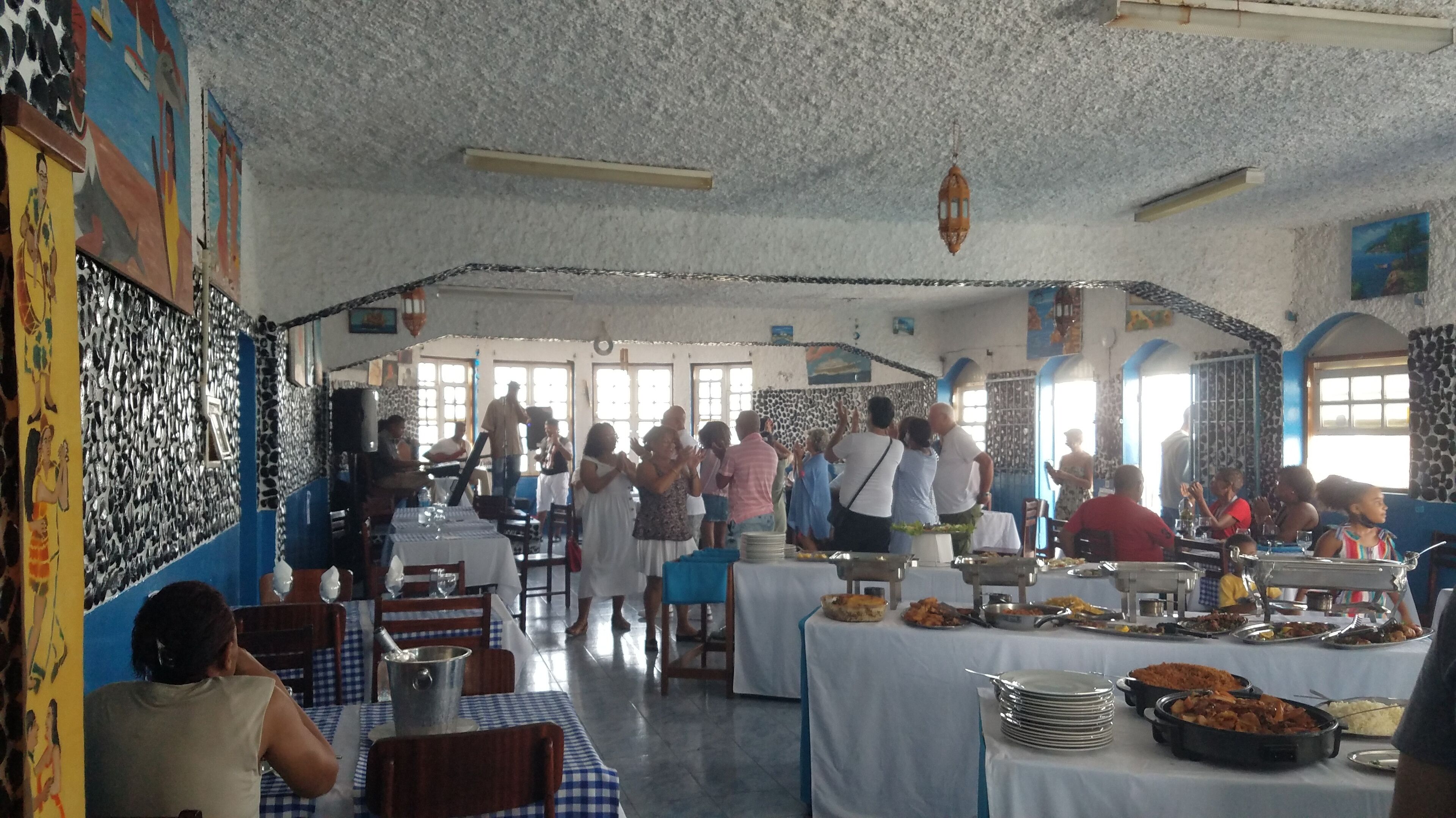A restaurant with a high ceiling and patterned walls, featuring a buffet setup with various dishes.