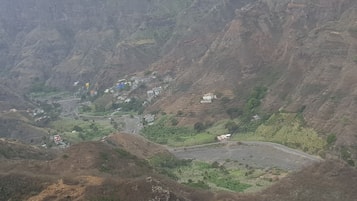 A mountainous landscape with terraced fields and scattered buildings.