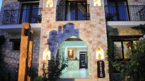 A stone building with a reception area, arched windows, and balconies. - Palates Village Hotel (Droushia)