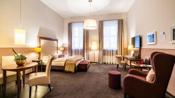 Een hotelkamer met een bed, een bureau, een stoel, een tafel en een bank.