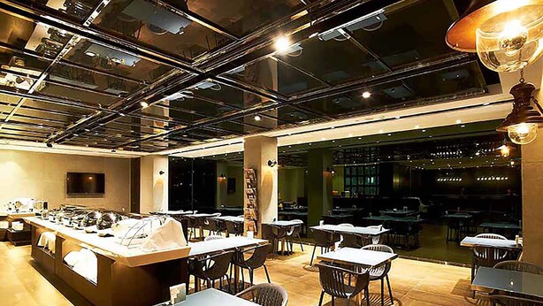A modern restaurant with a central bar, multiple dining tables, and chairs. - Royal Group Hotel Bo Ai Branch (Kaohsiung)