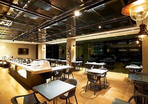 A modern restaurant with a central bar, multiple dining tables, and chairs. - Royal Group Hotel Bo Ai Branch (Kaohsiung)