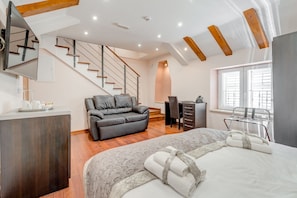 Une chambre d’hôtel moderne équipée d’un lit, d’un canapé, d’un bureau et d’un escalier.
