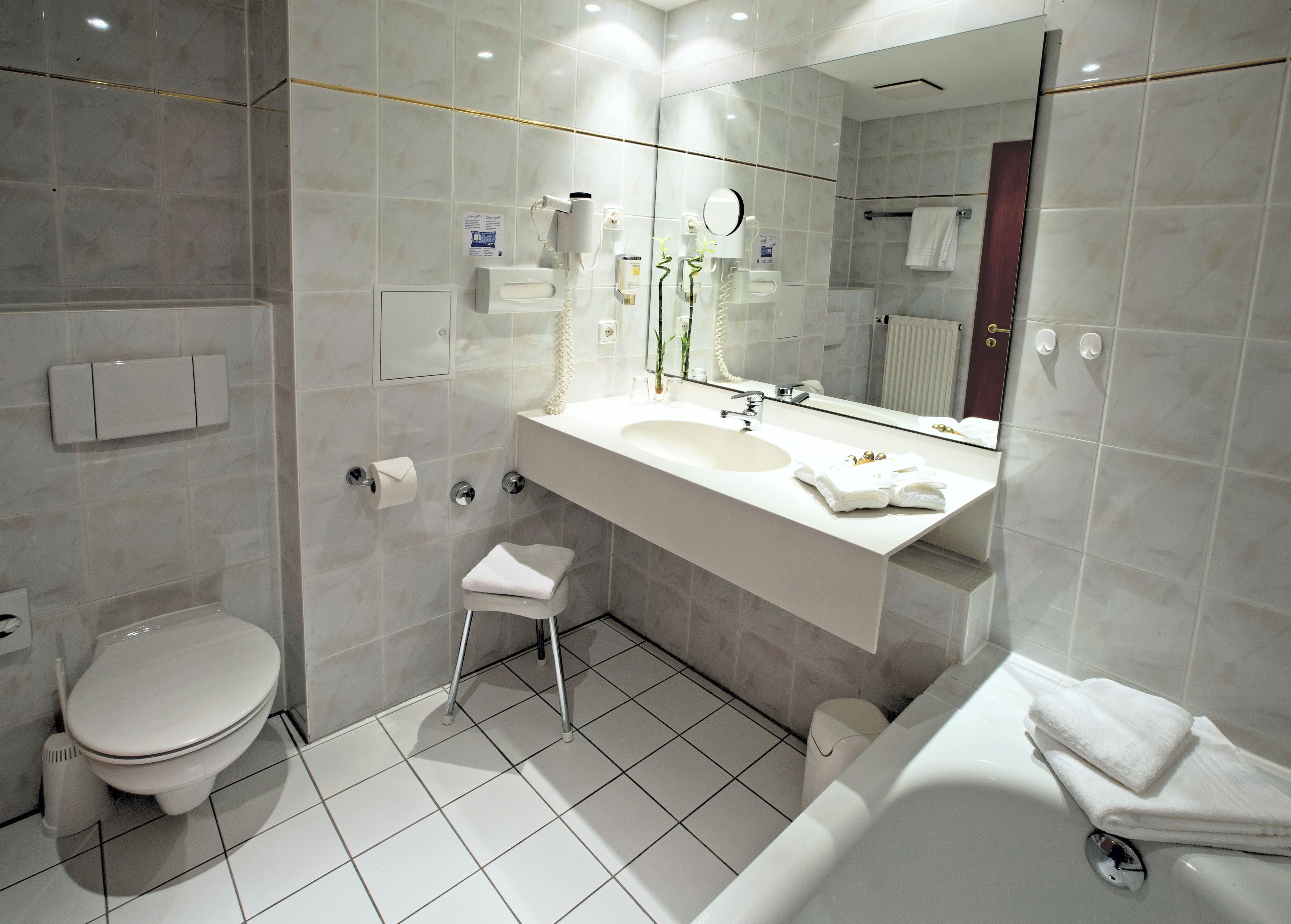 A modern bathroom with a toilet, sink, and bathtub.