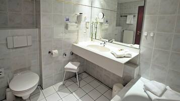 A modern bathroom with a toilet, sink, and bathtub.