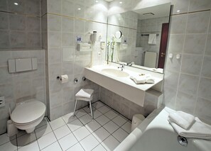 A modern bathroom with a toilet, sink, and bathtub. - Alpina Lodge Hotel Oberwiesenthal (Oberwiesenthal)
