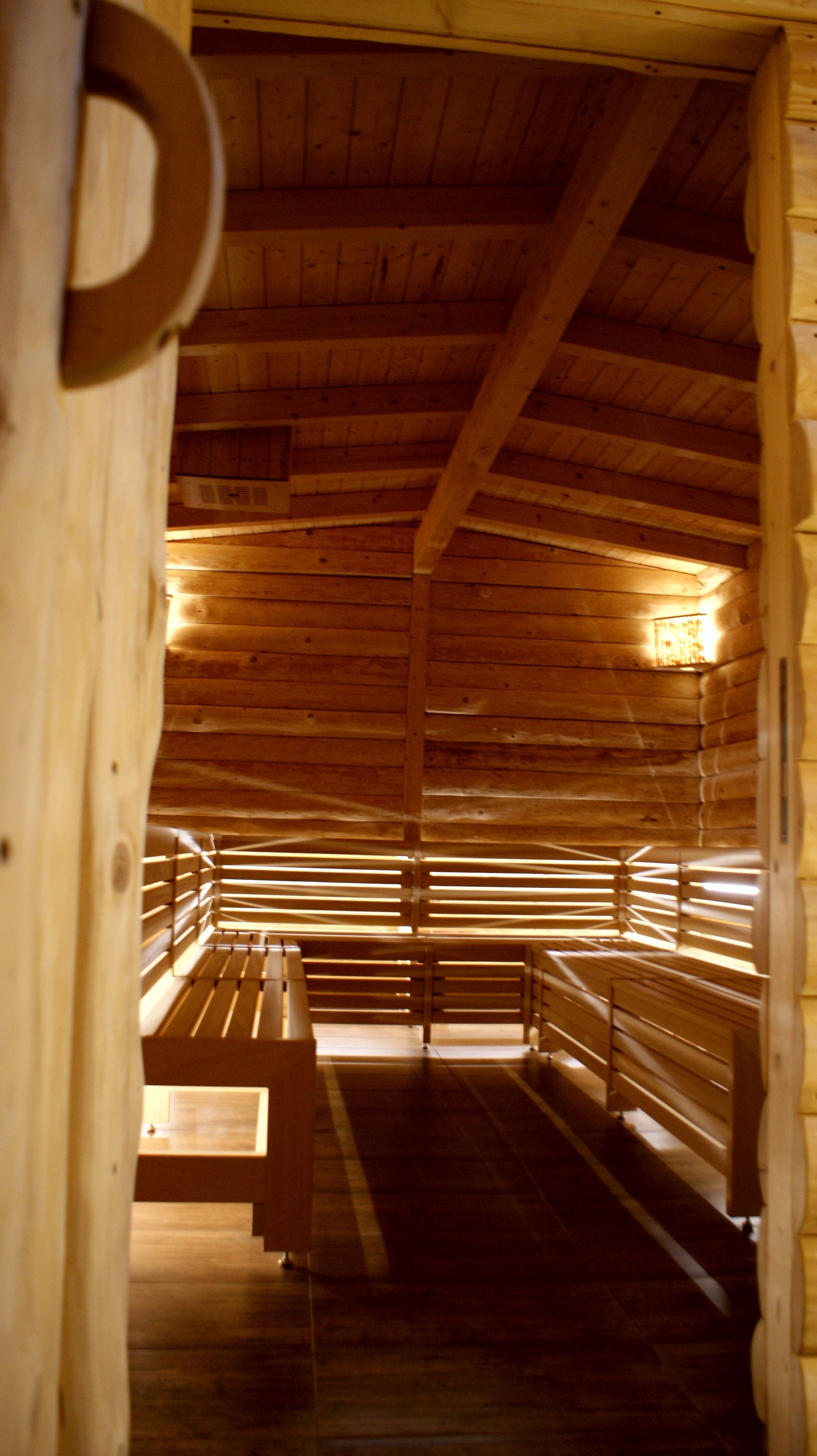 A wooden interior with benches and a sloped ceiling.