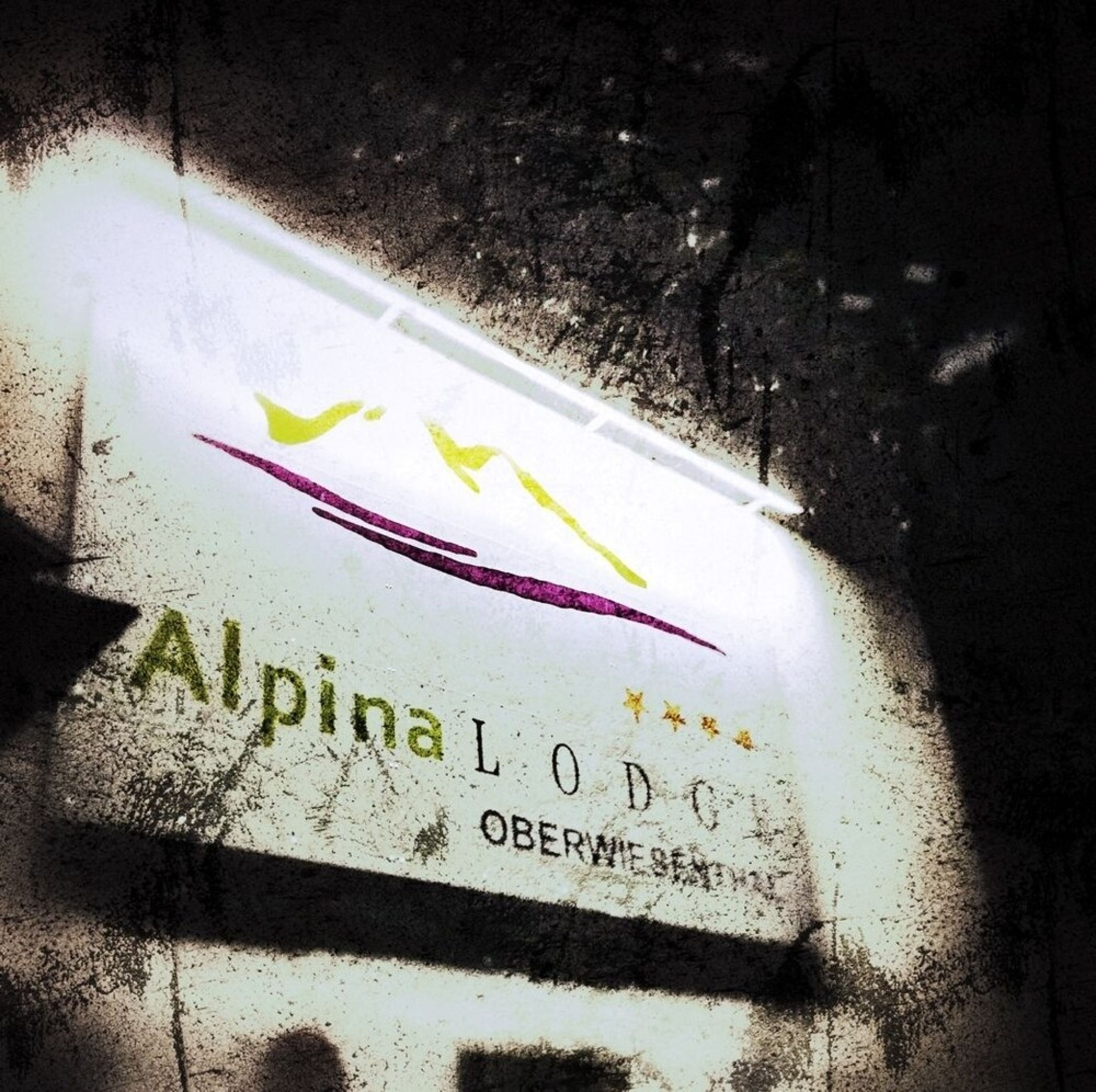 A sign with the text "Alpina LODC" and "OBERWIE BENZ."