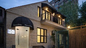 Un edificio de dos pisos con escaparate de vidrio y un balcón con barandilla de metal.
