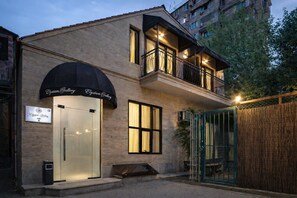 A two-story building with a glass storefront and a balcony with metal railings. - Elysium Gallery Hotel (Yerevan)