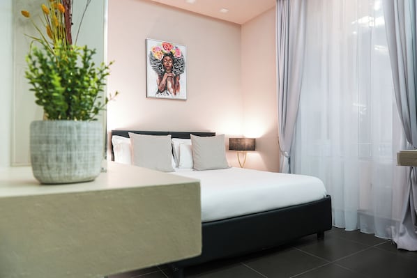 A modern bedroom with a bed, bedside table, and a potted plant.