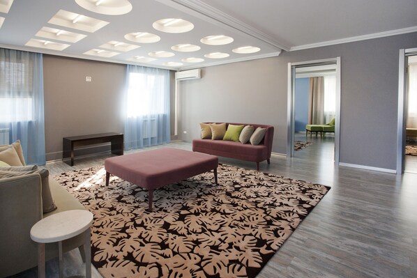 A modern living room with a sofa, a coffee table, and a patterned rug.
