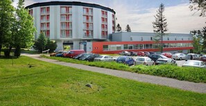 A multi-story building with a parking lot in front. - Atrium Hotel (Vysoké Tatry)