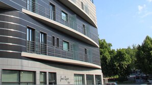 A modern hotel with a curved facade, multiple balconies, and large windows. - Hotel José Régio (Portalegre)