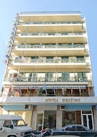 Un hotel de varios pisos con balcones, un cartel que dice 