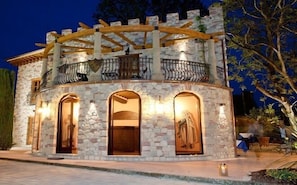 A stone building with a wooden balcony and arched windows. - Castello dei Templari (Lucca)