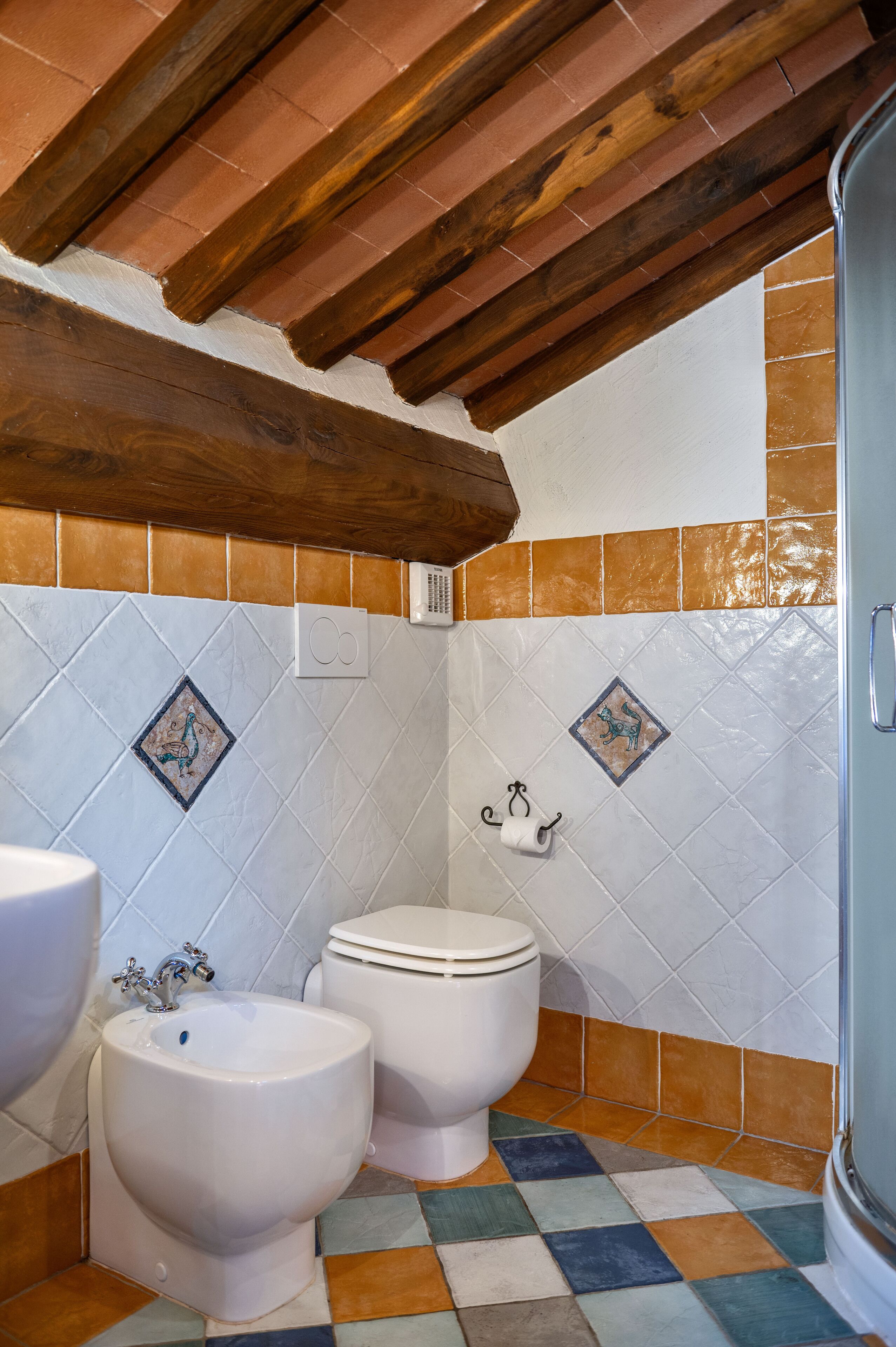 A bathroom with a bidet, toilet, and sink.