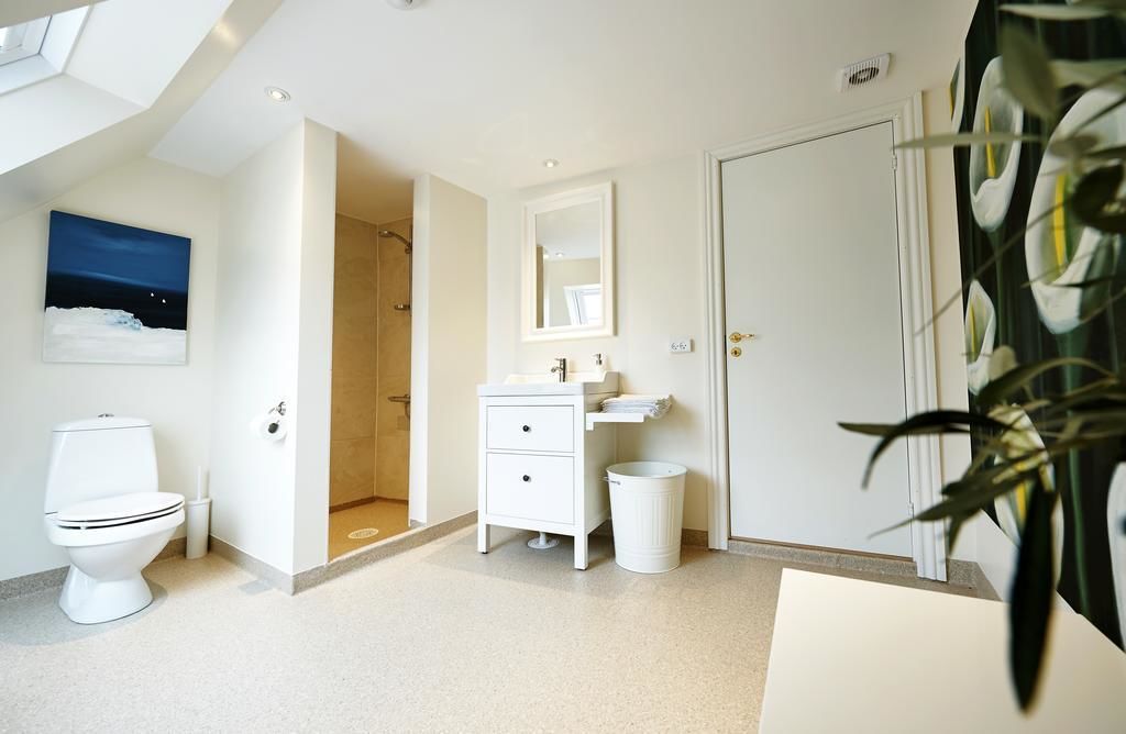 Un baño moderno con inodoro, lavamanos y ducha.