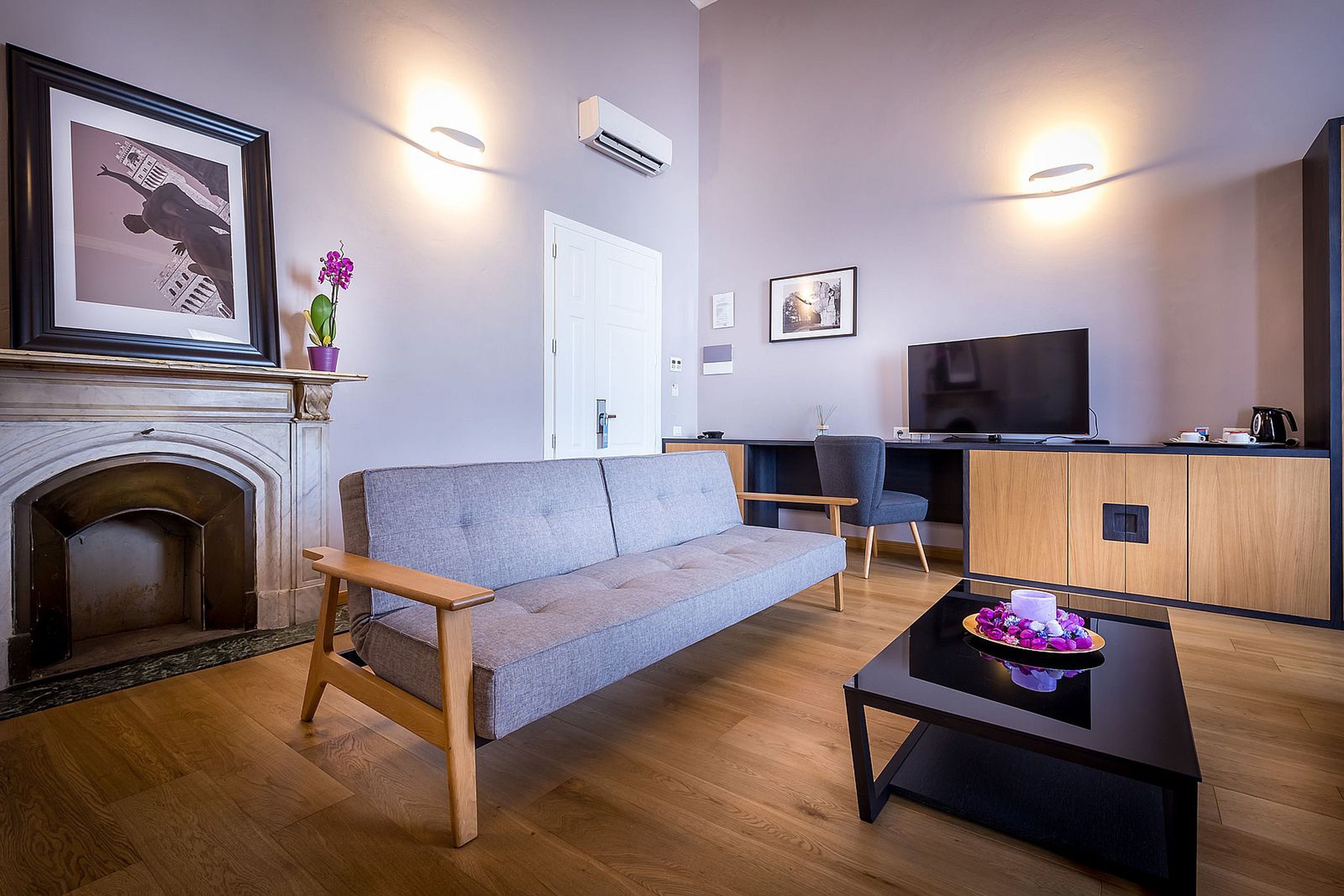 Ein modernes Wohnzimmer mit einer Couch, einem Couchtisch, einem Fernseher und einem Kamin.