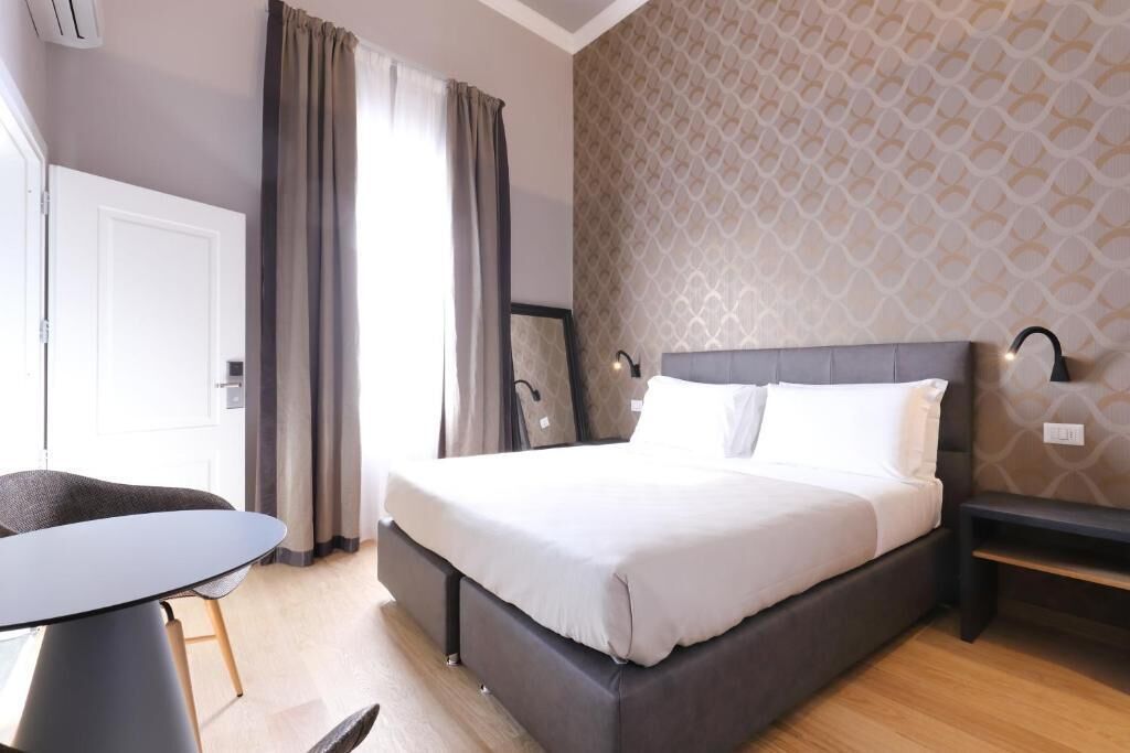Una habitación de hotel con una cama, un escritorio y una silla.