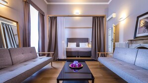 A modern hotel room with a large bed, two sofas, a coffee table with a decorative item, and a framed picture on the wall. - La Torre Del Cestello (Florence)