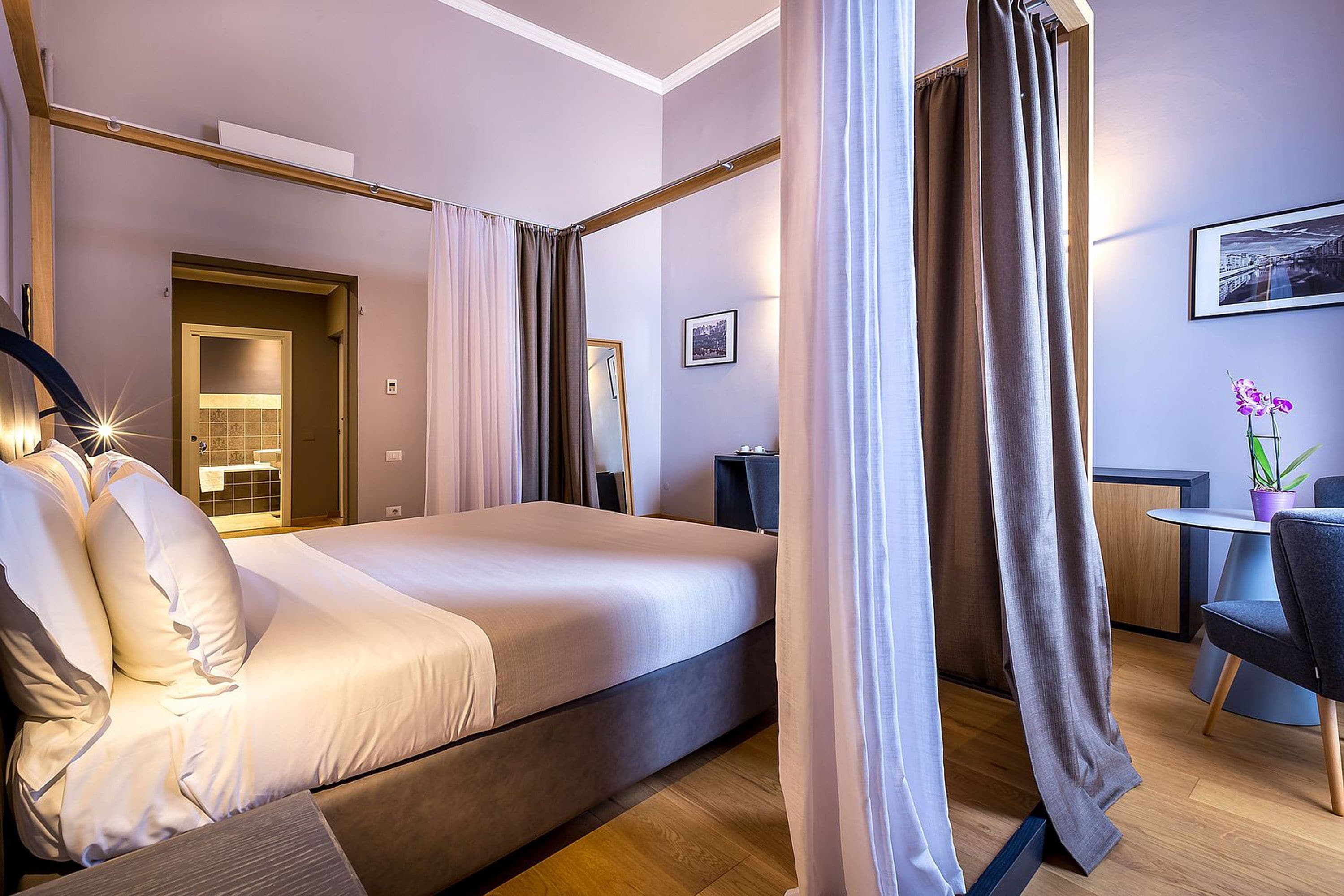 Ein modernes Hotelzimmer mit einem großen Bett, einem Schreibtisch und einem Stuhl.