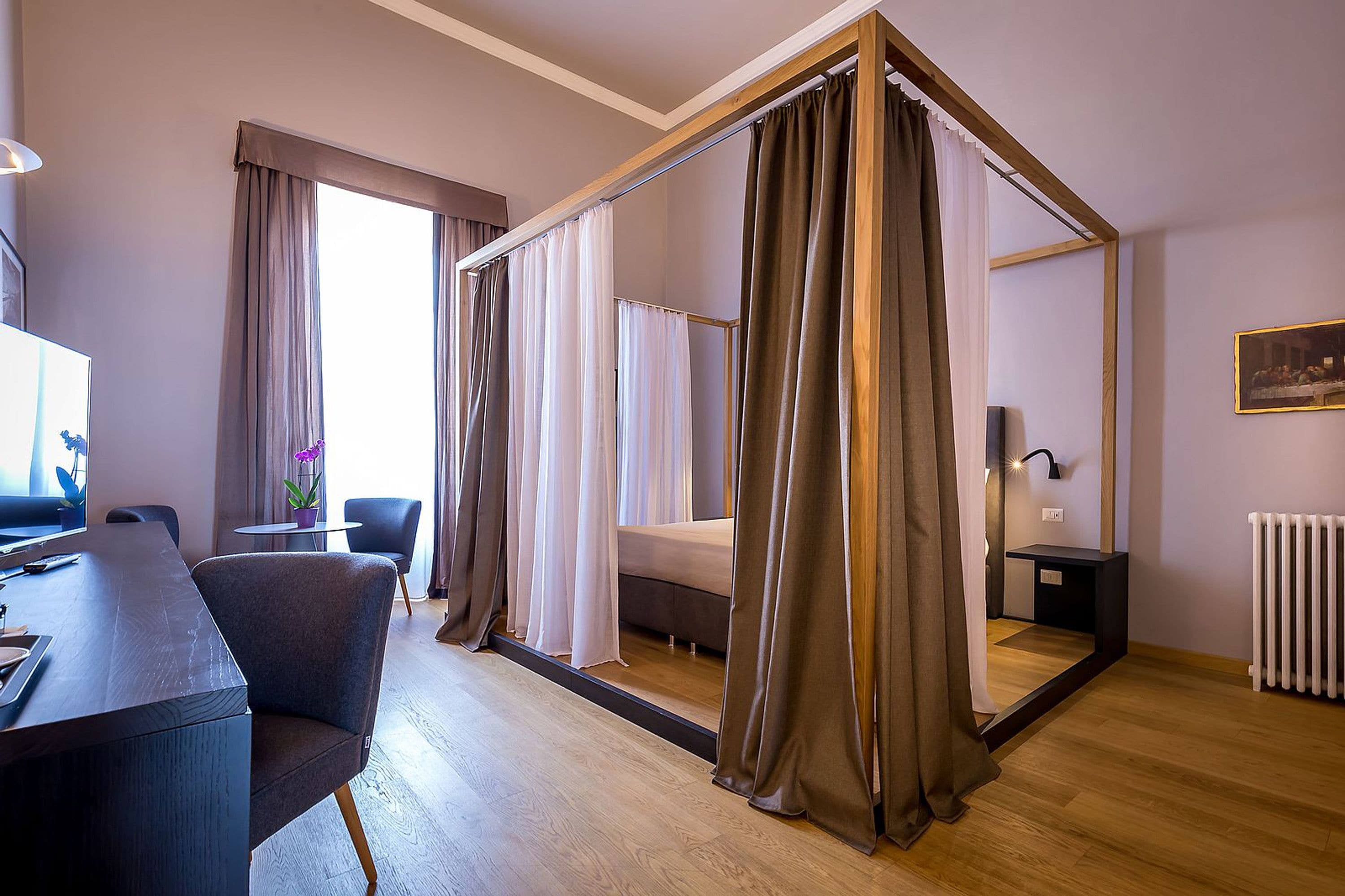 Een moderne hotelkamer met een groot bed, een bureau en een stoel.