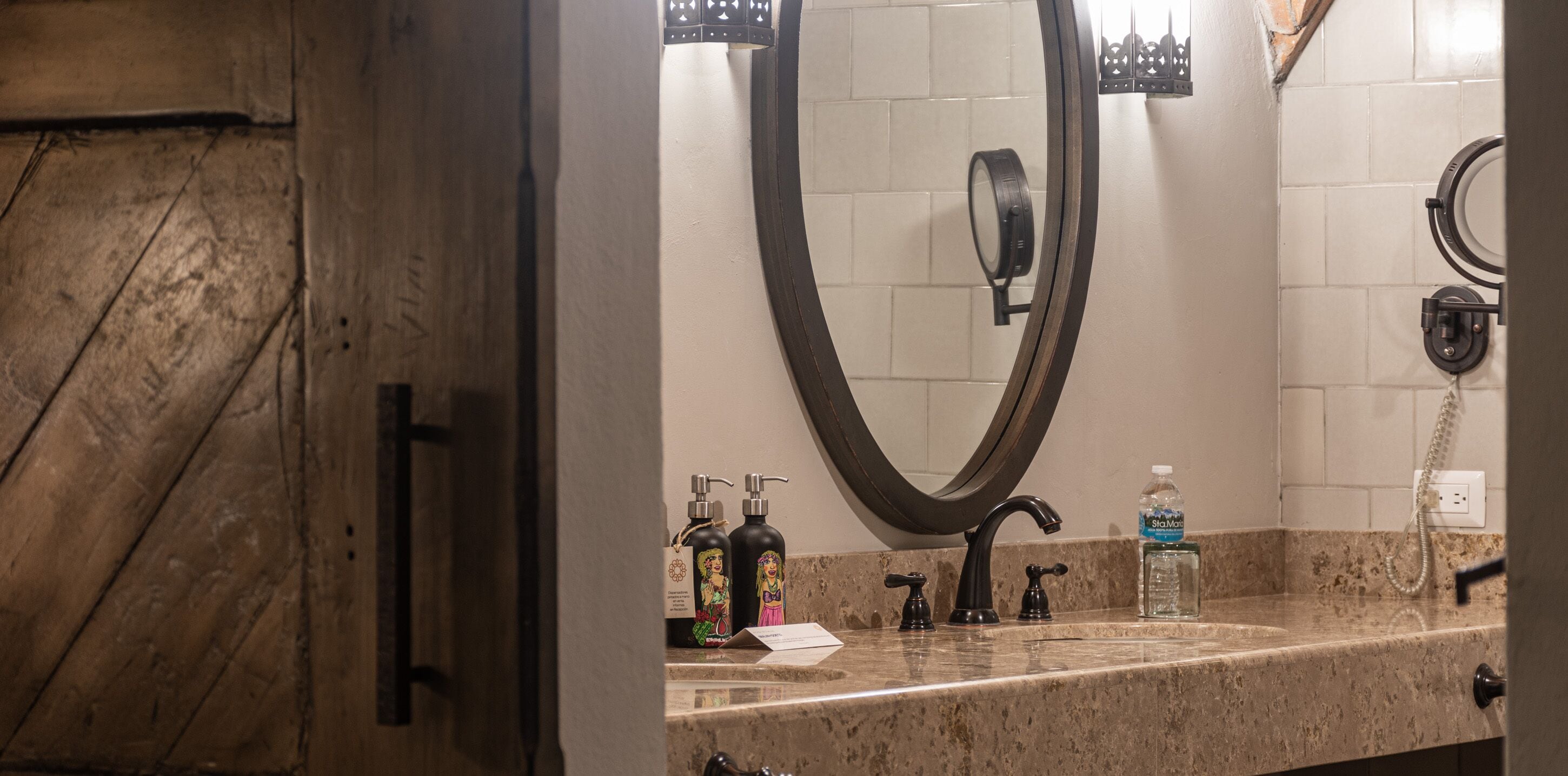 A bathroom with a large mirror, a towel rack, and a sink with toiletries.