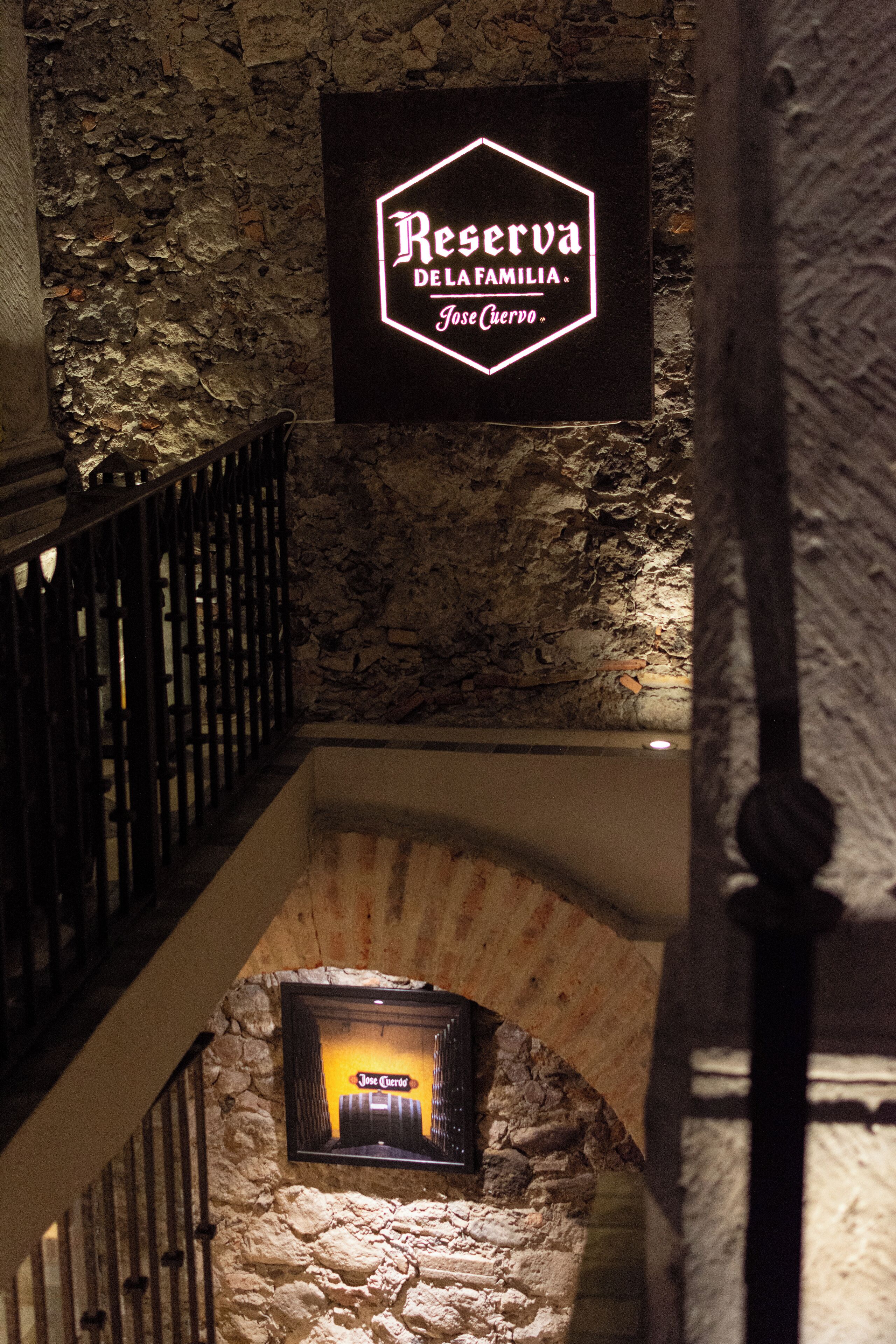 Un muro de piedra con un letrero de neón para Reserva Del Familia Jose Cuervo.