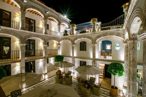 A multi-level courtyard with outdoor seating, potted plants, and a staircase.