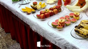A buffet table with various food items and a decorative centerpiece. - San Phillip Flat Hotel (Fortaleza)