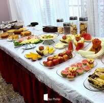 Uma mesa de buffet com diversos alimentos e um arranjo decorativo.